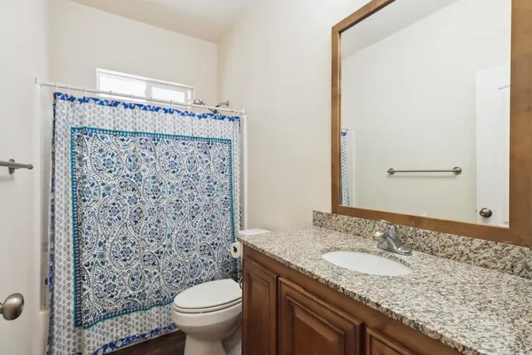 a bathroom with a granite countertop sink toilet and shower