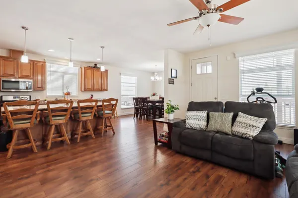 a living room with furniture kitchen view and a wooden floor