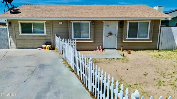 a view of a house with wooden fence next to a yard