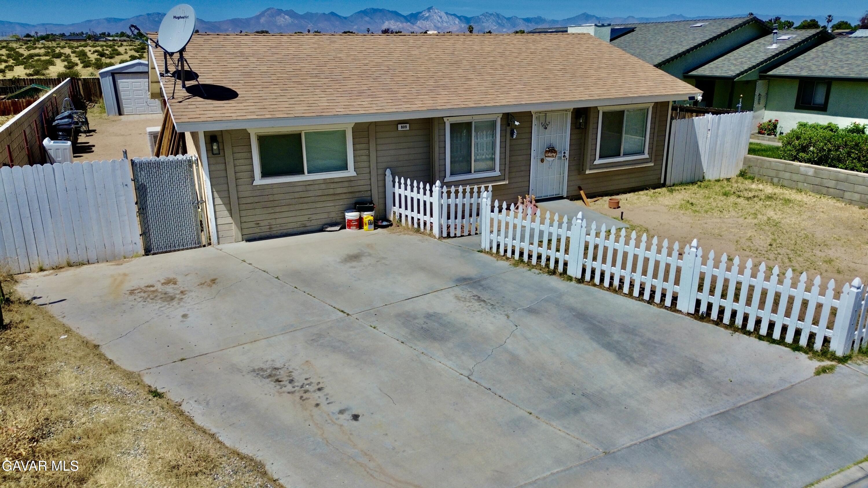 809 South Sunset Street Ridgecrest, CA 93555 - Photo 18 of 21 a view of a house with a wooden fence