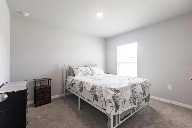 a bed sitting in a bedroom next to a window