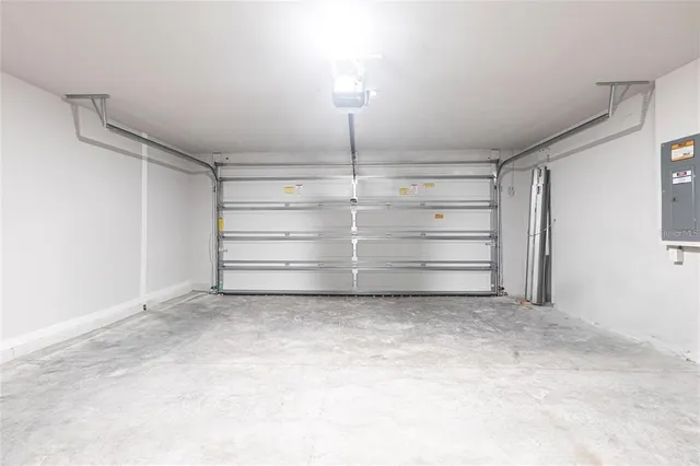 a view of a white house with a big yard potted plants and large tree