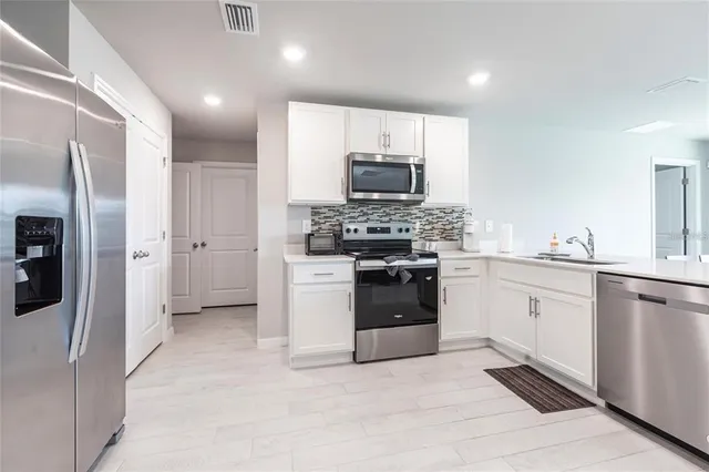 a kitchen with stainless steel appliances a refrigerator stove and sink