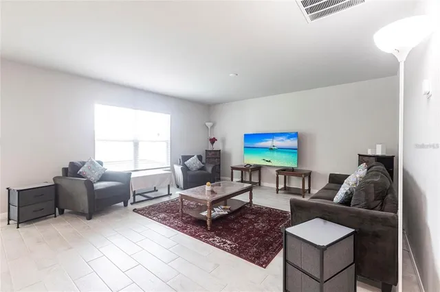 a living room with furniture a rug and a window