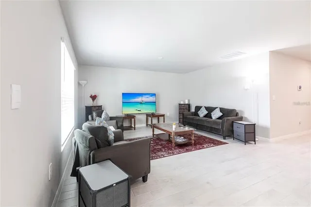a living room with furniture a rug and a window