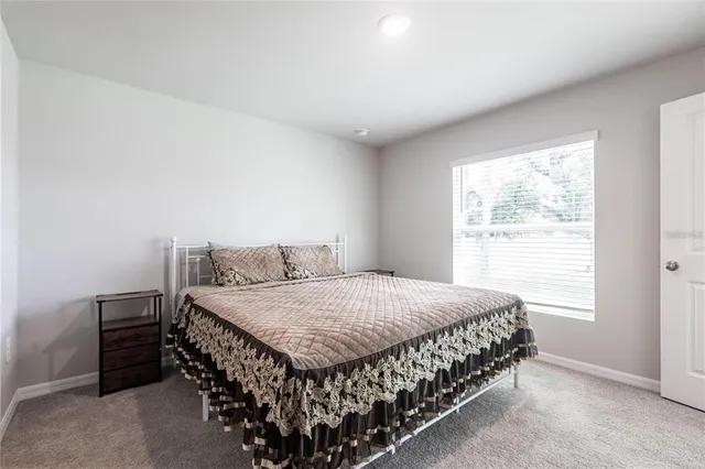 a bed sitting in a bedroom next to a window