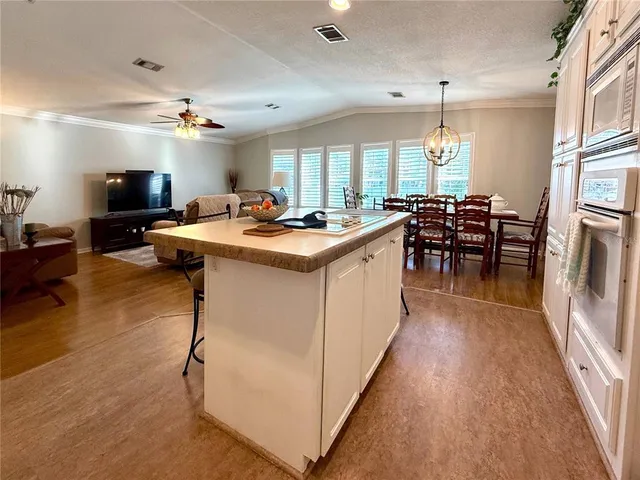 a kitchen with kitchen island a sink a counter top space appliances and a center island