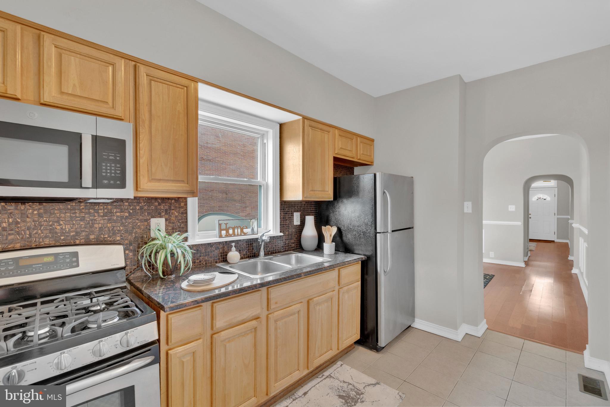 255 South Conkling Street Baltimore, MD 21224 - Photo 13 of 33 a kitchen with stainless steel appliances granite countertop a stove a sink and a refrigerator