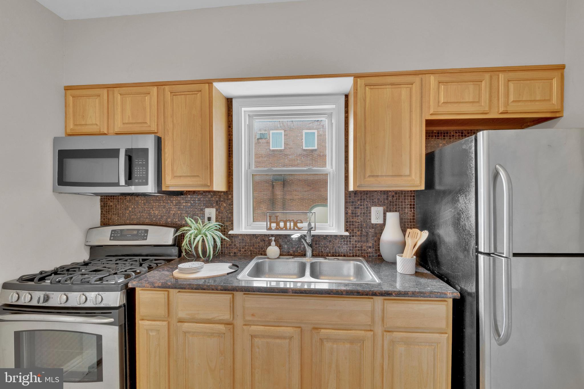 255 South Conkling Street Baltimore, MD 21224 - Photo 14 of 33 a kitchen with granite countertop a sink stove and refrigerator