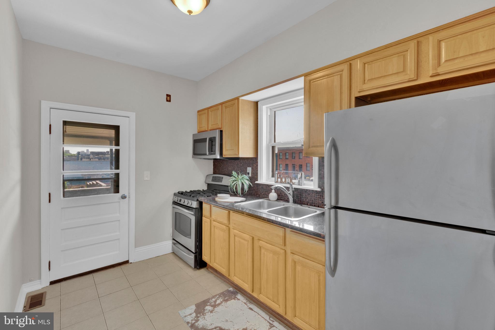 255 South Conkling Street Baltimore, MD 21224 - Photo 15 of 33 a kitchen with stainless steel appliances granite countertop a refrigerator a stove and a sink with cabinets