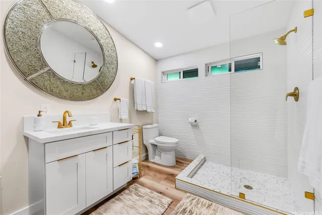 a bathroom with a sink mirror vanity and toilet