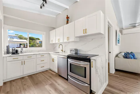 a kitchen with granite countertop cabinets stainless steel appliances and a wooden floor