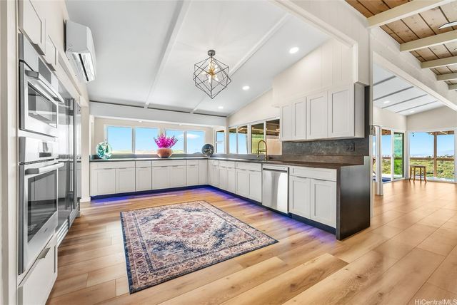 a kitchen with stainless steel appliances granite countertop a lot of counter space and wooden floor