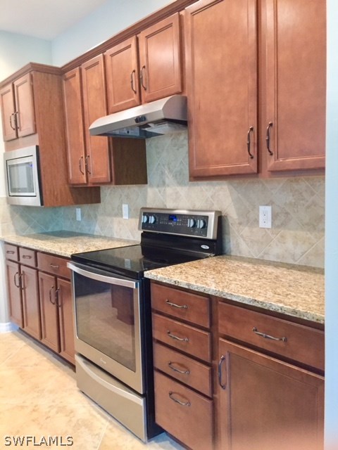 10840 Dennington Road Fort Myers, FL 33913 - Photo 8 of 35 a kitchen with stainless steel appliances granite countertop wooden cabinets a stove a sink and dishwasher