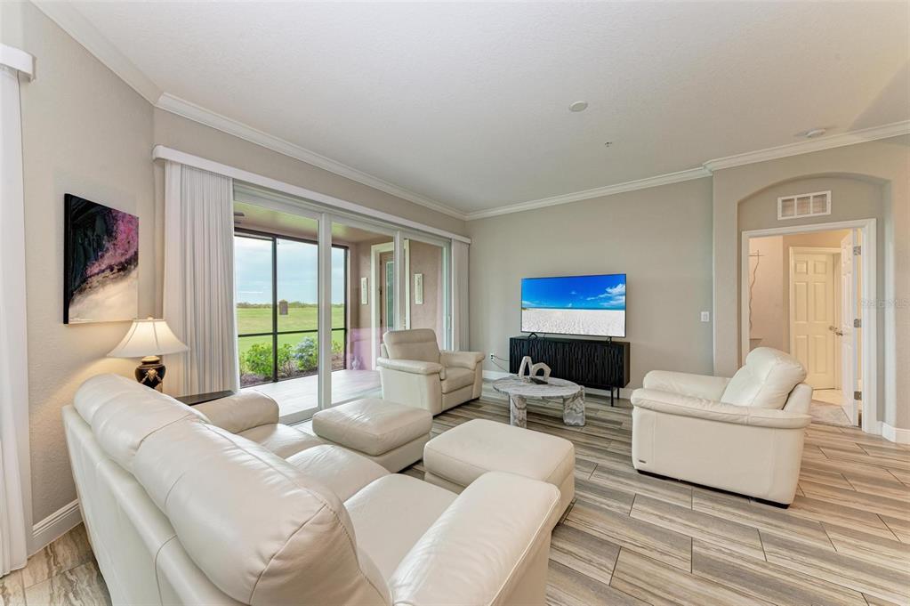 7374 Divot Loop Bradenton, FL 34202 - Photo 11 of 43 a living room with furniture a flat screen tv and a large window