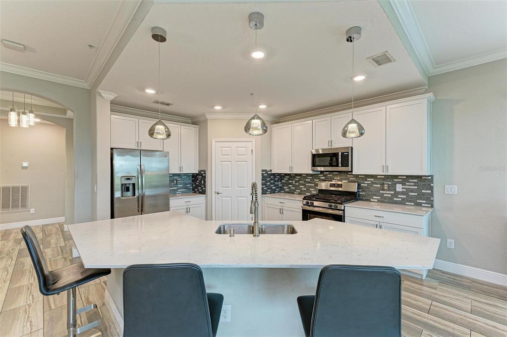 7374 Divot Loop Bradenton, FL 34202 - Photo 7 of 43 a kitchen with counter top space cabinets and stainless steel appliances