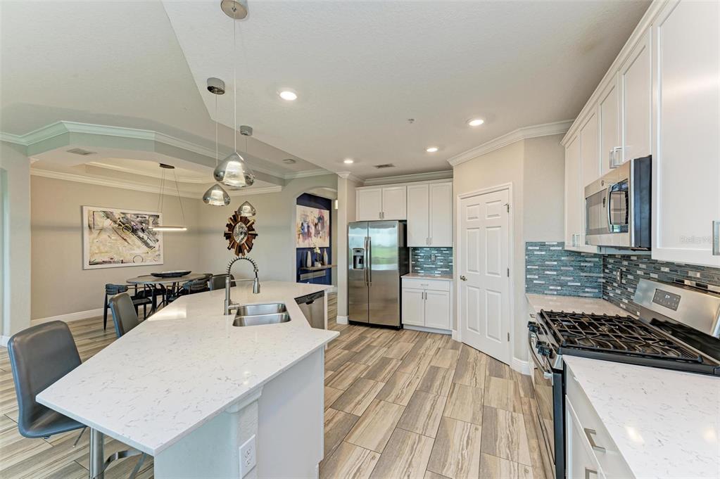7374 Divot Loop Bradenton, FL 34202 - Photo 8 of 43 a large kitchen with a counter space a sink stainless steel appliances and cabinets