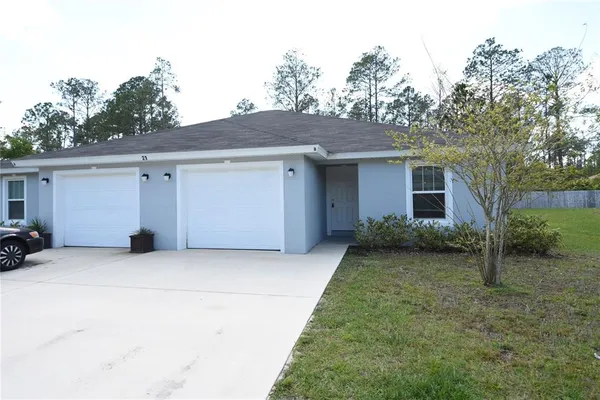a view of a house with a yard and garage