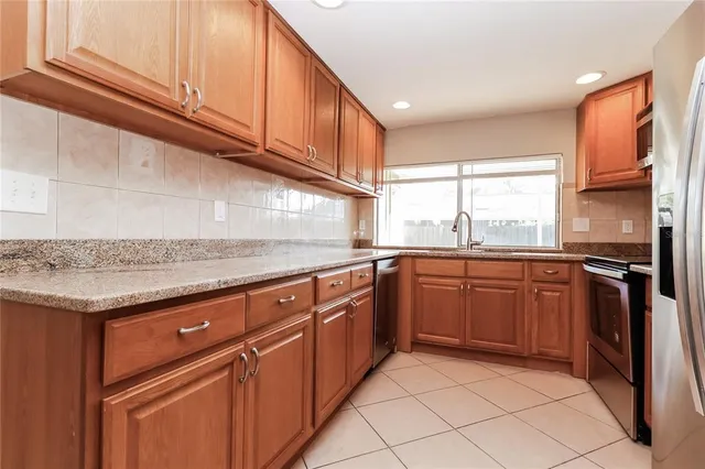 a kitchen with granite countertop stainless steel appliances and sink