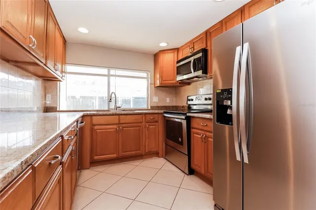 a kitchen with stainless steel appliances granite countertop a refrigerator and a sink