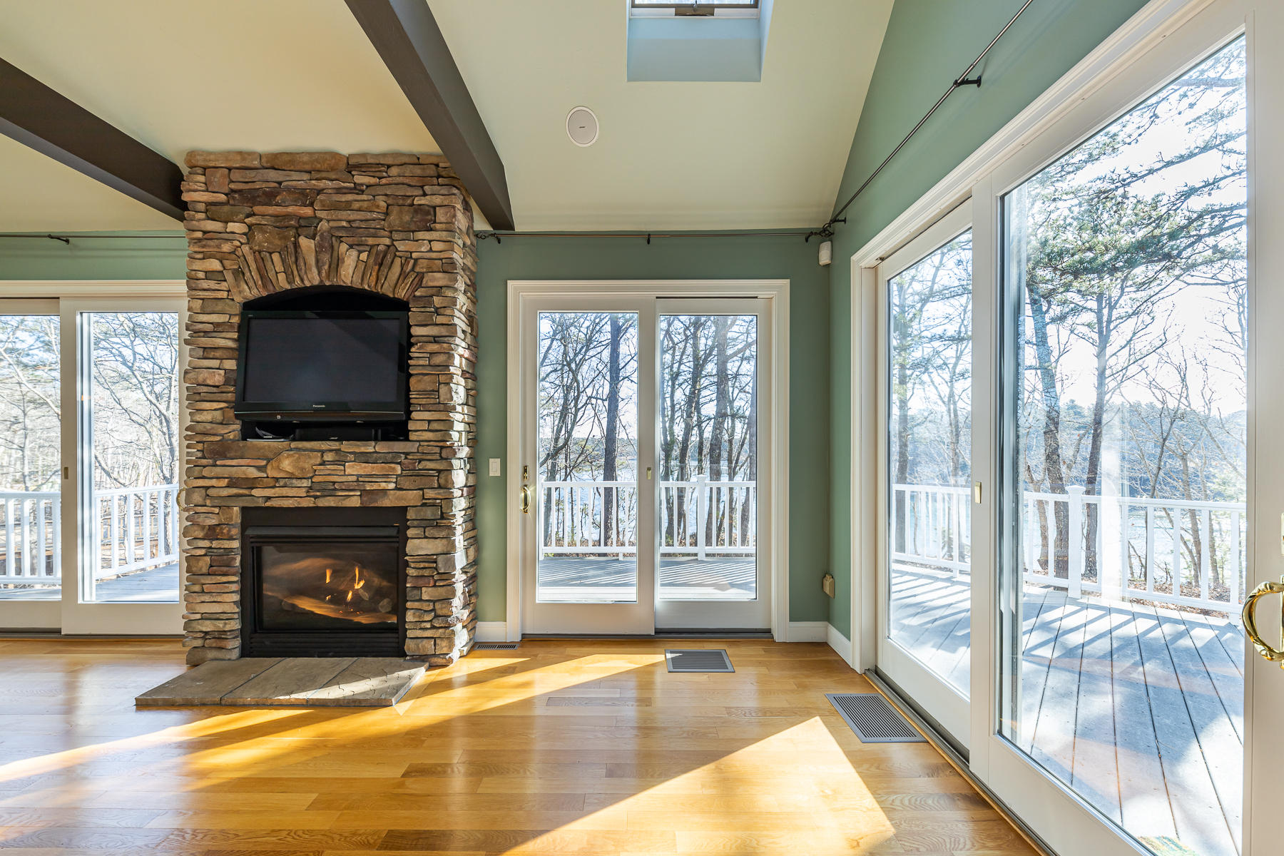 26 Quaker Run Road Mashpee, MA 02649 - Photo 50 of 56 a view of a livingroom with a fireplace wooden floor and windows