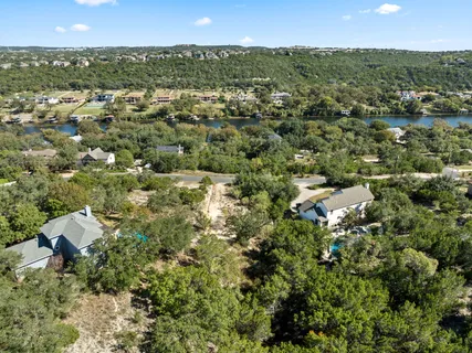 an aerial view of residential houses with outdoor space and trees