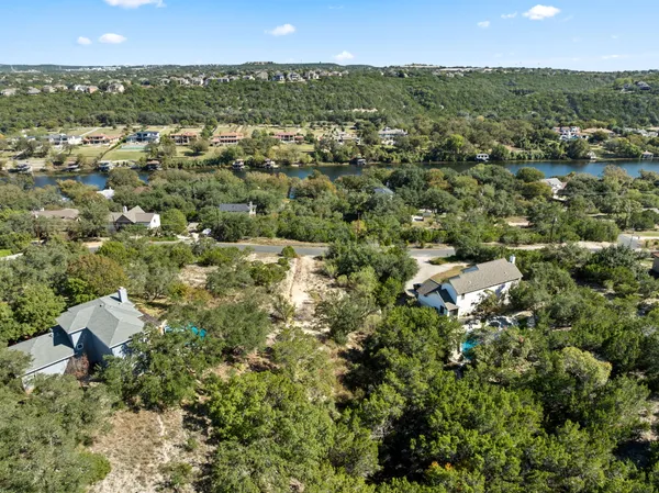 an aerial view of residential houses with outdoor space and trees