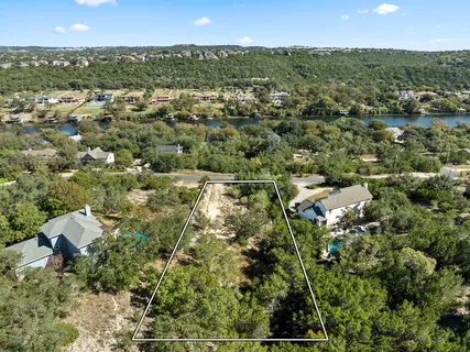 an aerial view of residential houses with outdoor space and trees