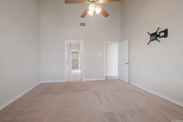 a view of an empty room with a chandelier fan
