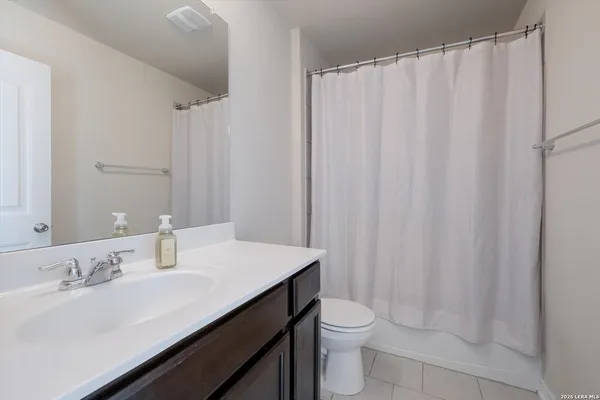 a bathroom with a sink a toilet and shower curtain