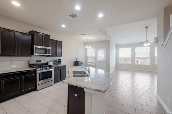 a kitchen with stainless steel appliances granite countertop a sink dishwasher stove and refrigerator