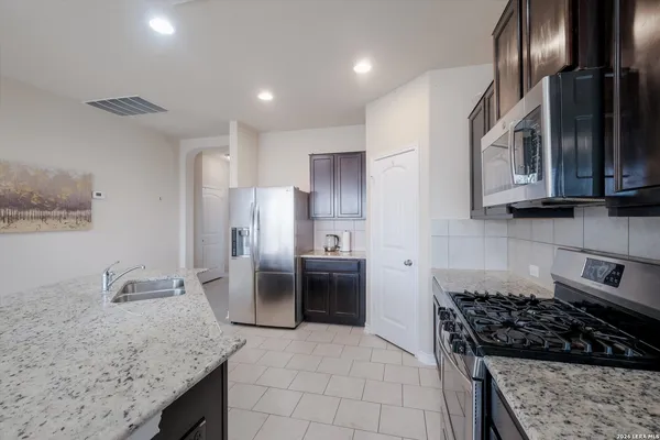 a kitchen with stainless steel appliances granite countertop a sink stove and refrigerator