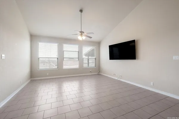 a view of an empty room with a fireplace and a flat screen tv