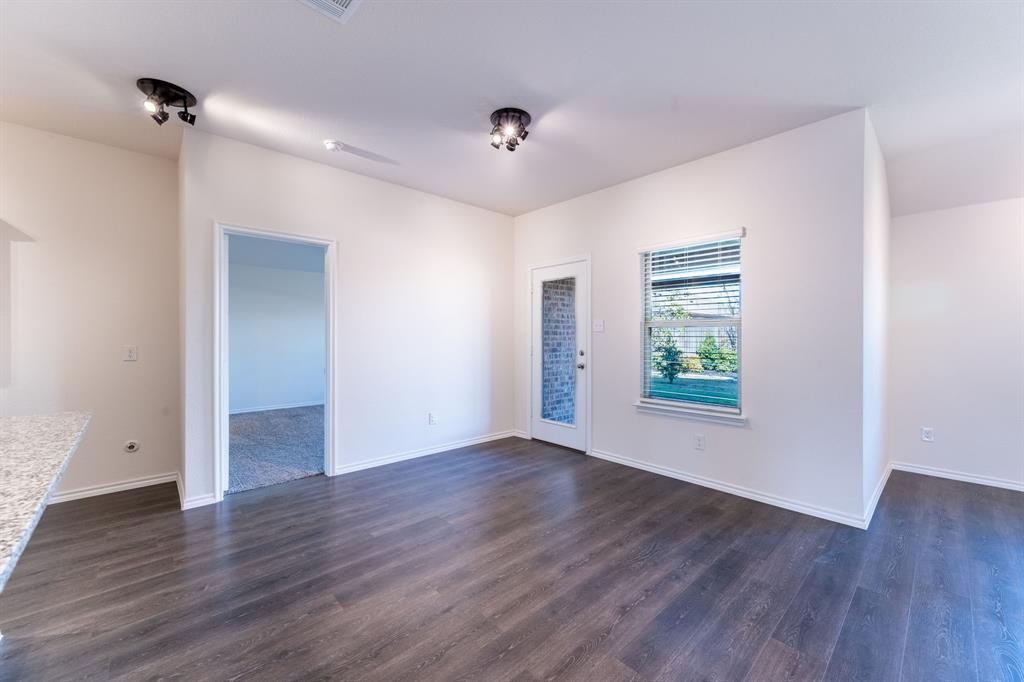 2101 Brisbon Street Fate, TX 75189 - Photo 12 of 39 a view of an empty room with wooden floor and a window