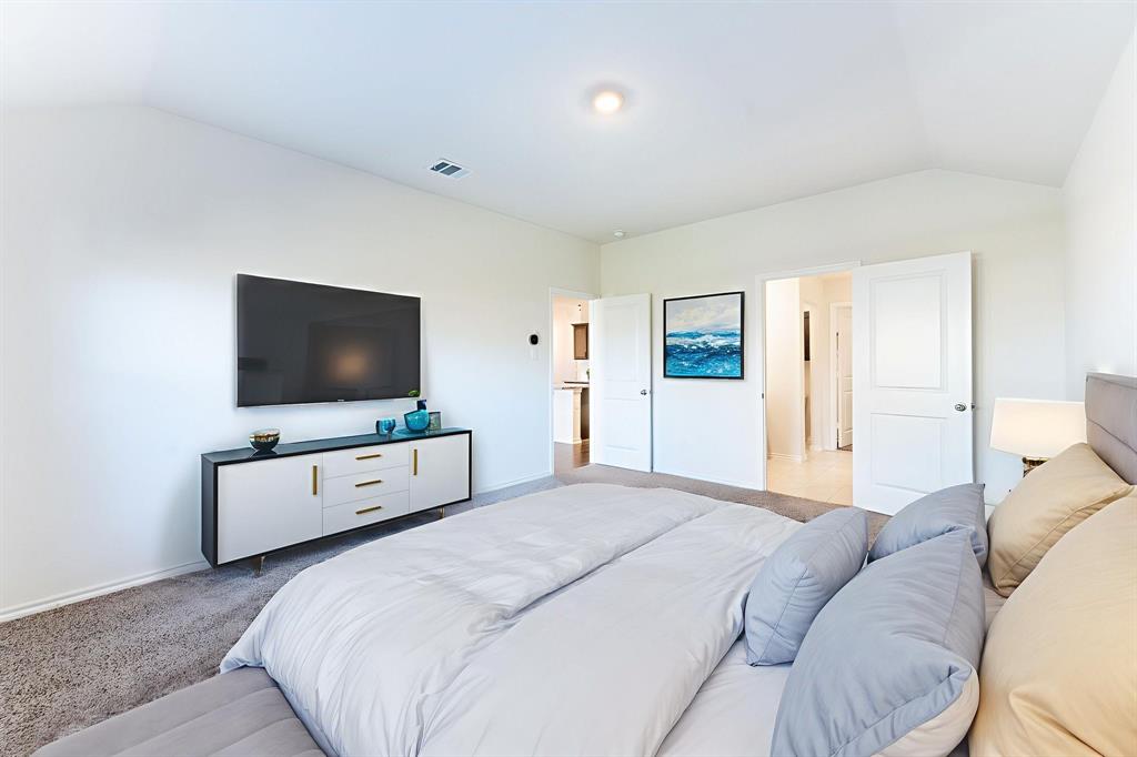 2101 Brisbon Street Fate, TX 75189 - Photo 18 of 39 a bedroom with a bed and a flat screen tv