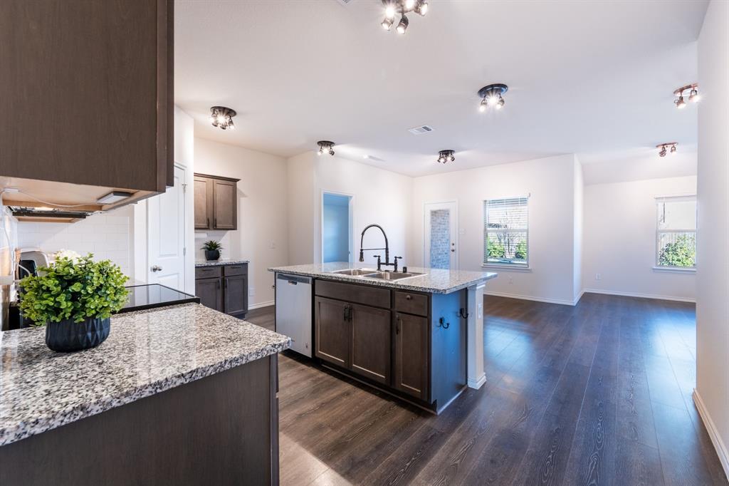 2101 Brisbon Street Fate, TX 75189 - Photo 7 of 39 a kitchen with sink stove and wooden floor