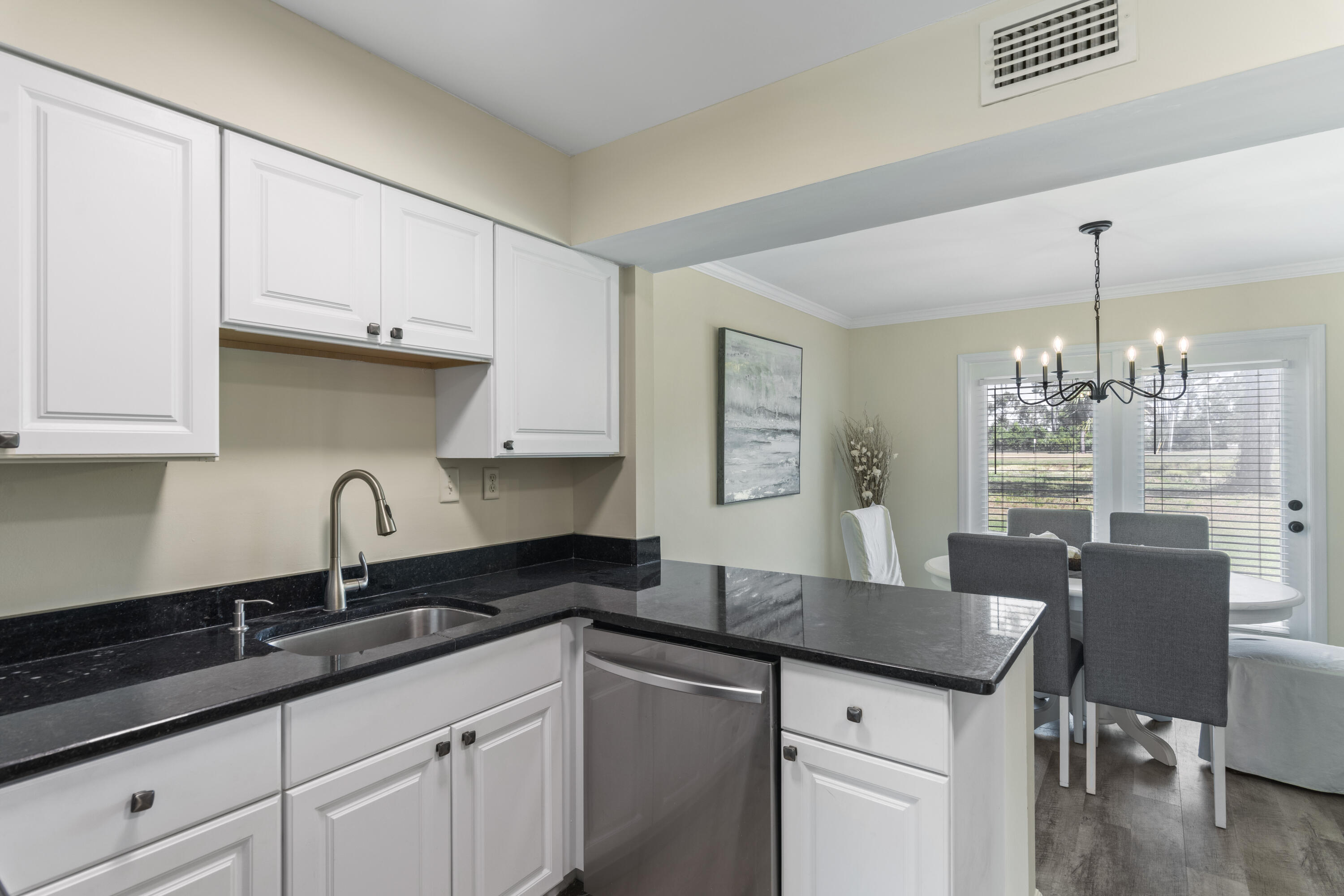 4300 Bay Point Road, Unit 402 Panama City Beach, FL 32408 - Photo 11 of 34 a kitchen with granite countertop a sink cabinets and wooden floor