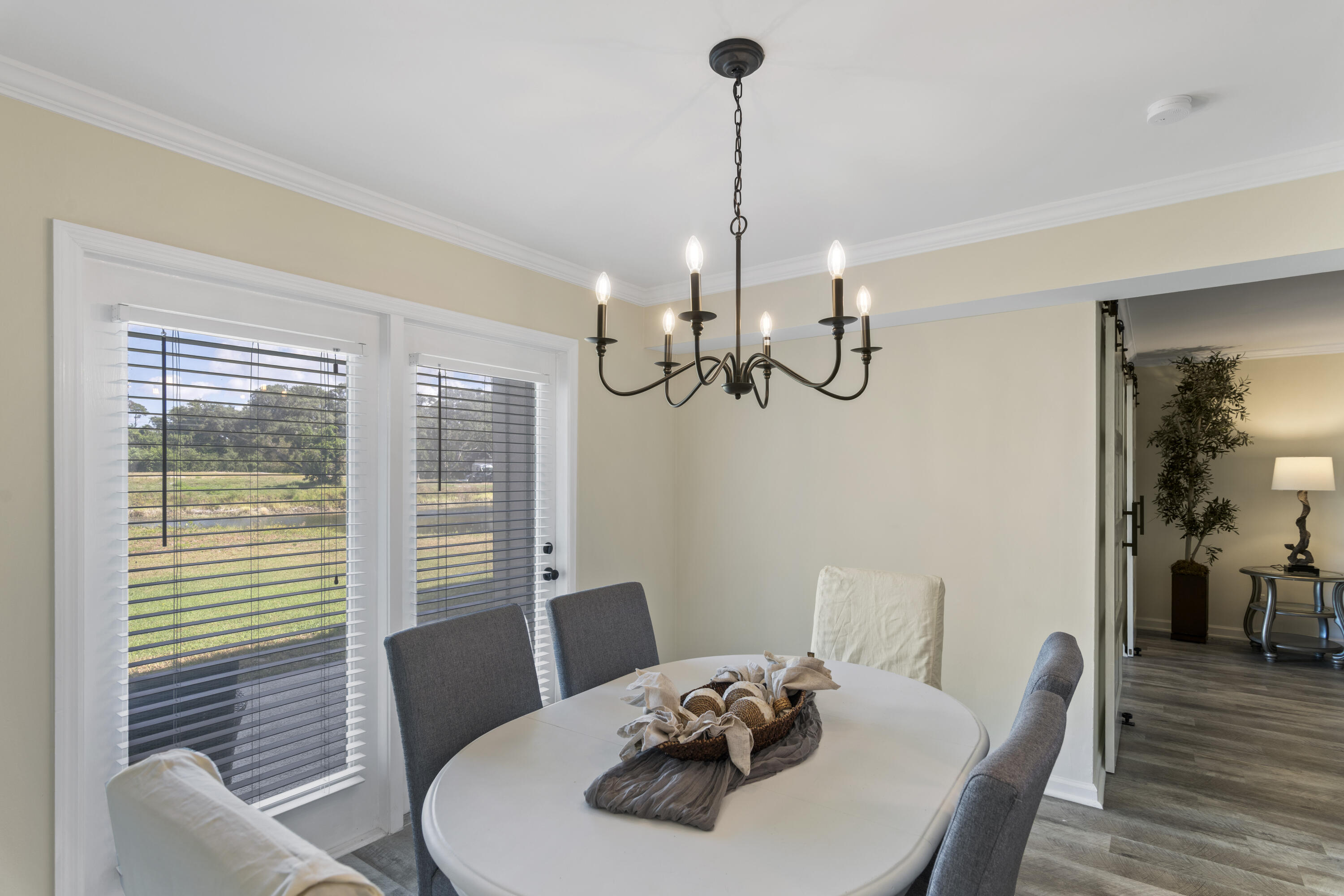 4300 Bay Point Road, Unit 402 Panama City Beach, FL 32408 - Photo 14 of 34 a view of a dining room with furniture wooden floor and chandelier
