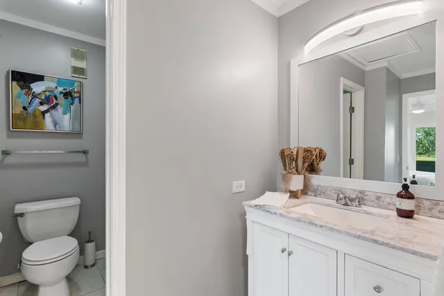 a bathroom with a granite countertop toilet sink and mirror