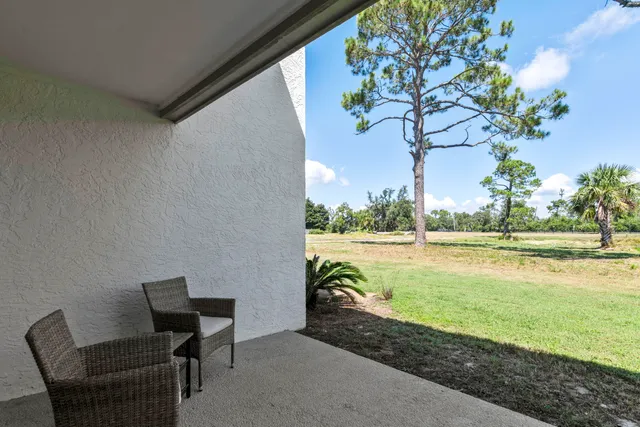 a view of a lake with table and chair and floor to ceiling window