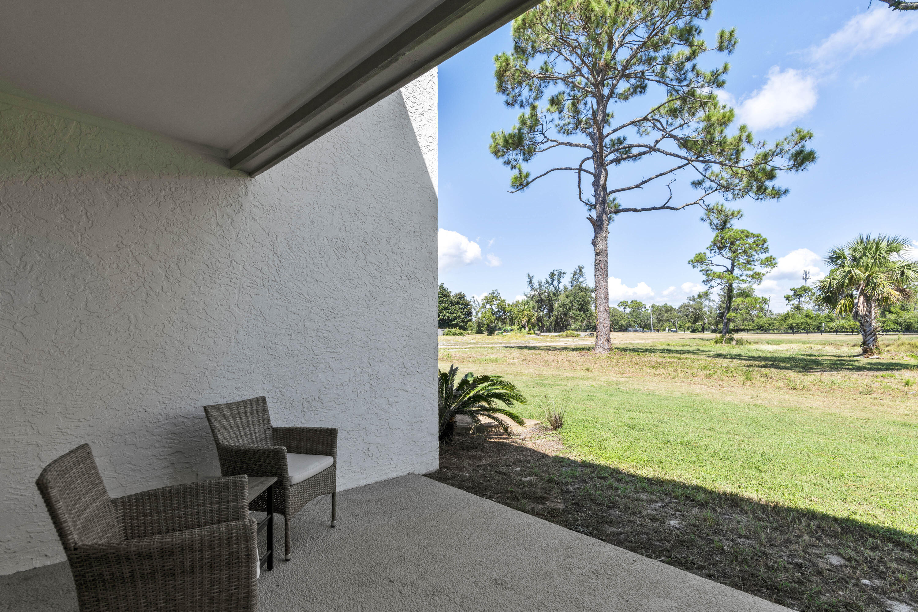 4300 Bay Point Road, Unit 402 Panama City Beach, FL 32408 - Photo 32 of 34 a view of a lake with table and chair and floor to ceiling window