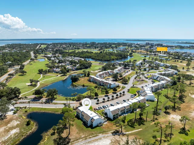 an aerial view of a city with lots of residential buildings and ocean view in back