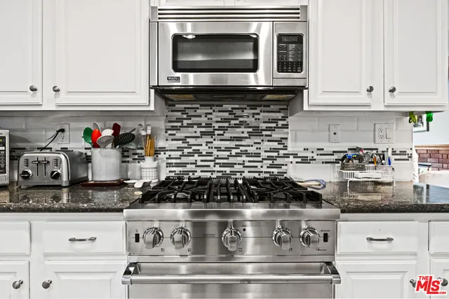 a kitchen with granite countertop a stove and a sink