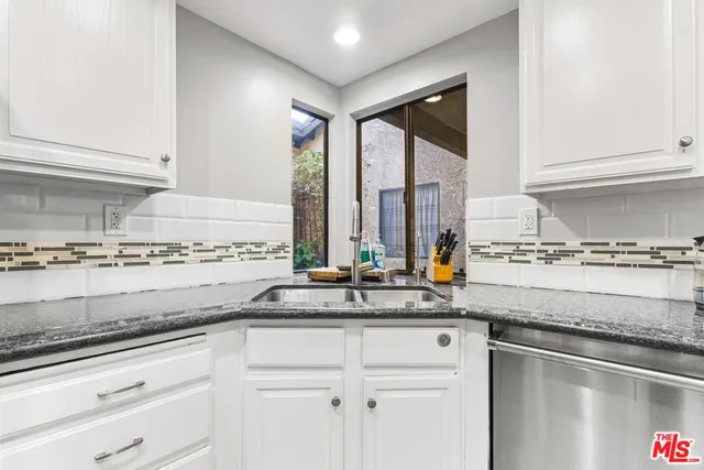 a kitchen with stainless steel appliances granite countertop a sink and a counter space