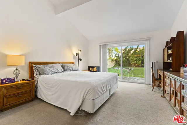 a bedroom with a bed and a flat tv screen on dresser