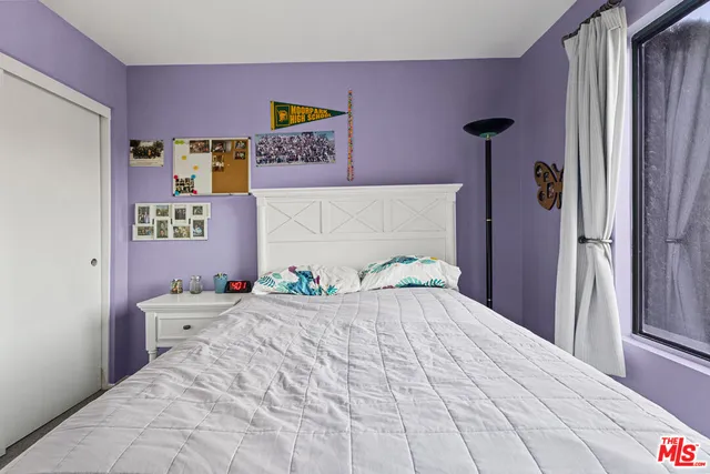 a bedroom with a bed and a wall painting