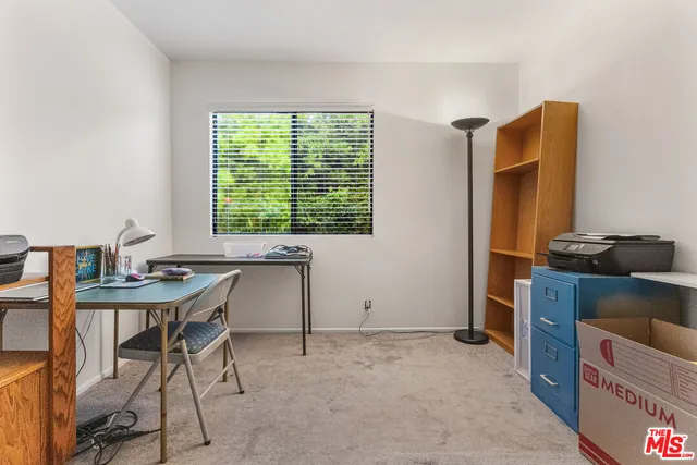 a view of a workspace with furniture and a window
