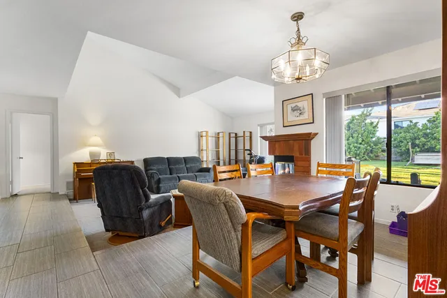 a dining room with furniture a chandelier and wooden floor
