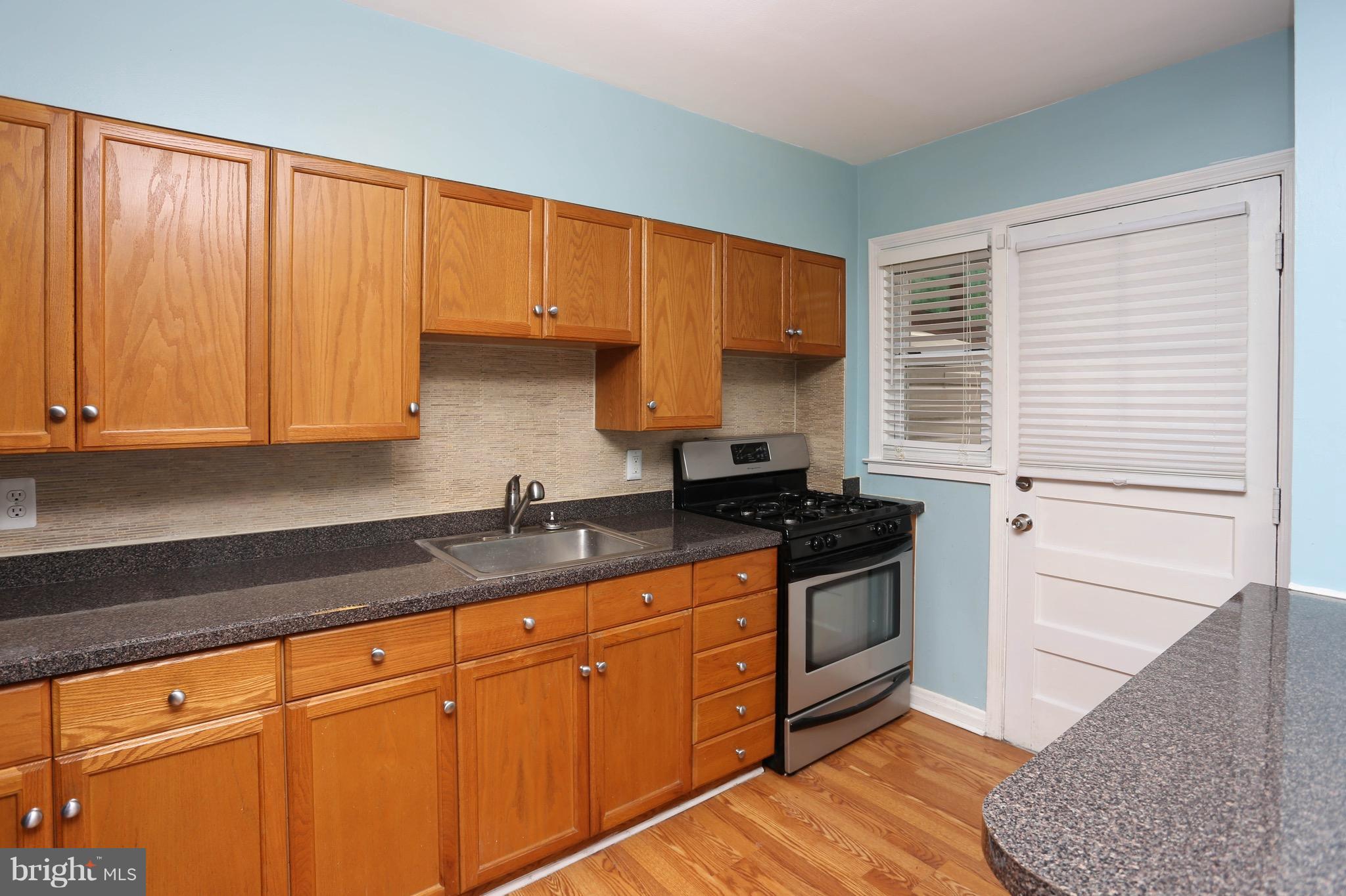 1957 Holborn Road Baltimore, MD 21222 - Photo 11 of 25 a kitchen with granite countertop a sink a stove and cabinets