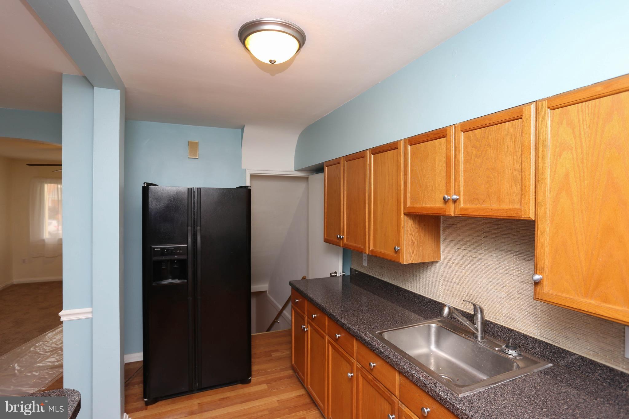 1957 Holborn Road Baltimore, MD 21222 - Photo 9 of 25 a kitchen with granite countertop a sink a refrigerator and a stove top oven